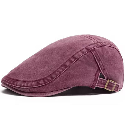 Purple flat cap with a gold buckle on a white background