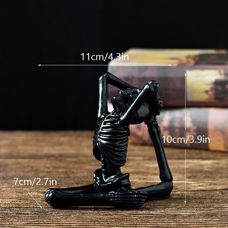 Skeletal yoga figurine on a wooden surface with measurements indicated.