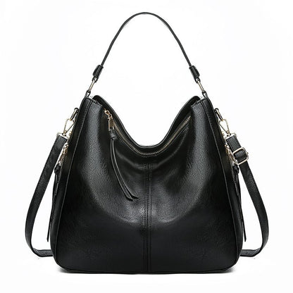 Black leather handbag with shoulder straps on a white background