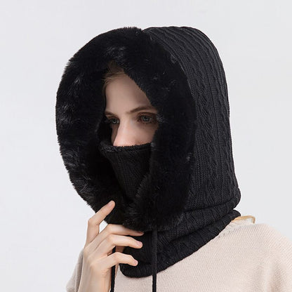 Person wearing a black knitted hood over their head and face on a light gray background