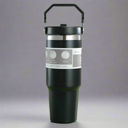 Black insulated tumbler with silver lid on a gray background