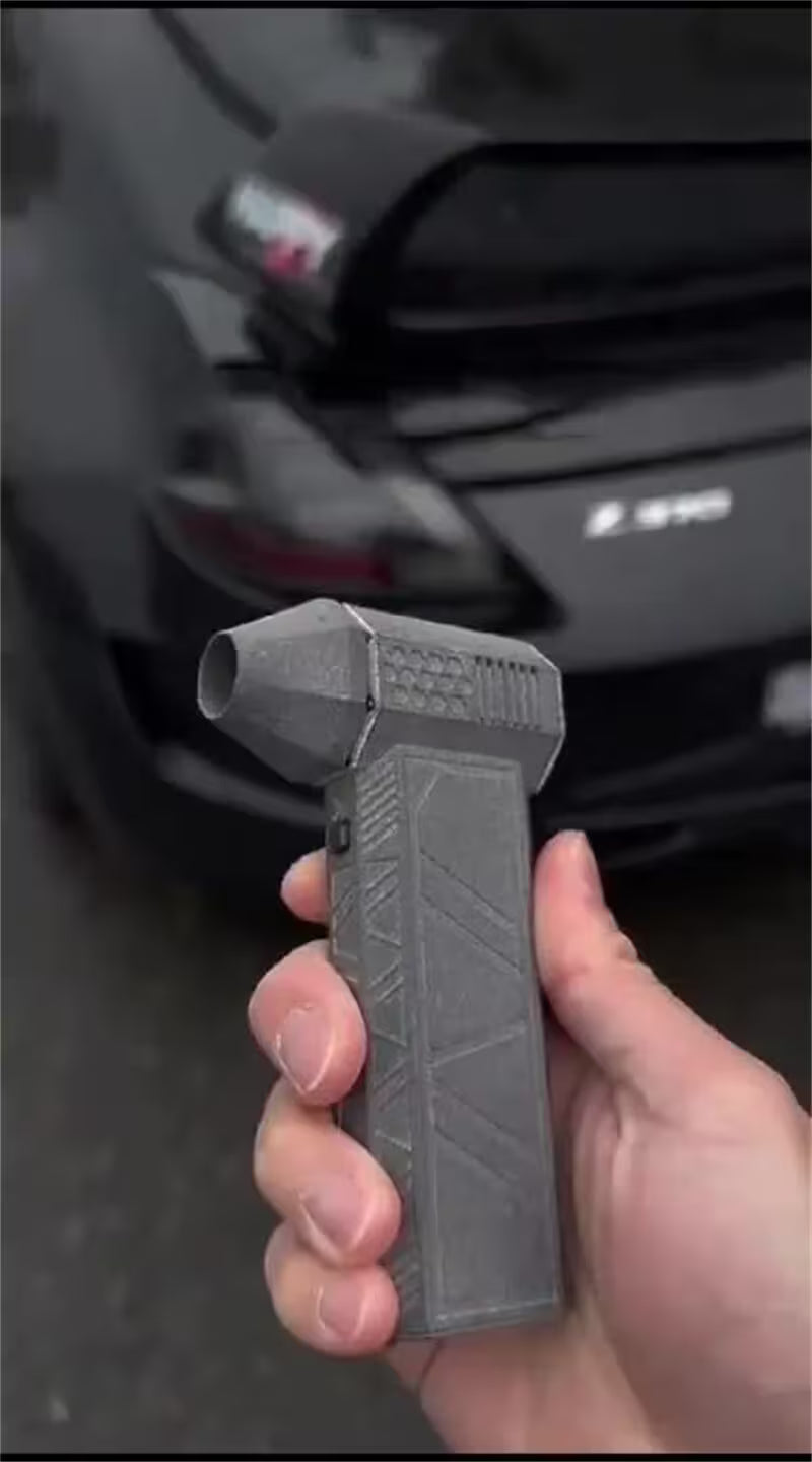 Hand holding a tactical gun magazine in front of a car