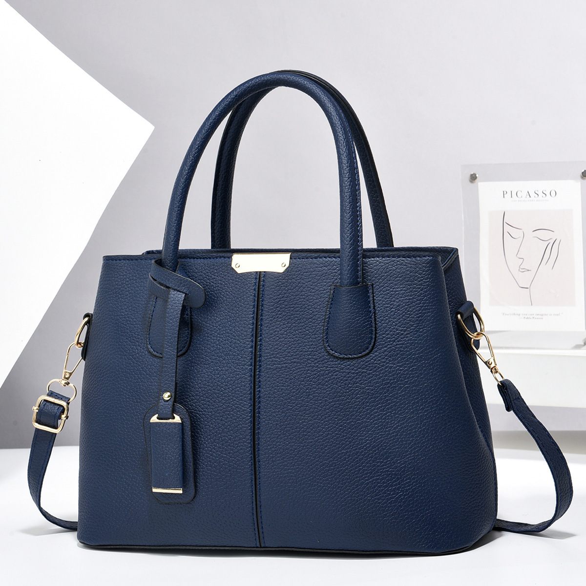 Navy blue handbag with gold accents on a white background
