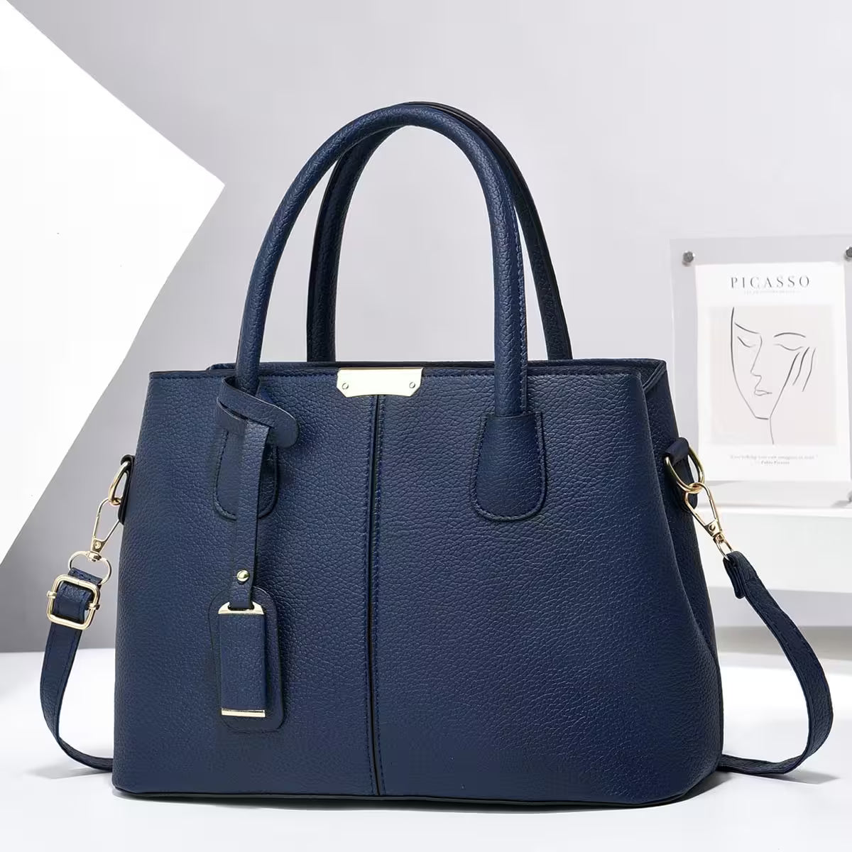 Blue handbag with gold accents on a white background