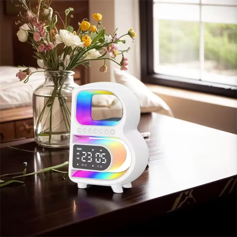 White night light with colorful display on a wooden surface next to a vase of flowers.