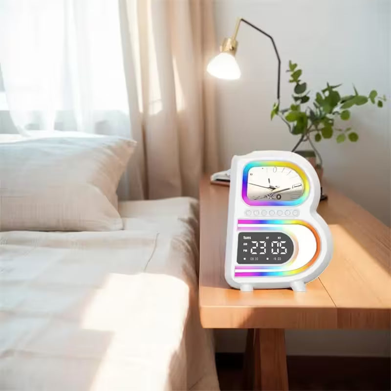Colorful digital clock on a bedside table with a bed and lamp in the background