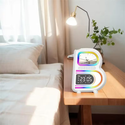 Colorful digital clock on a bedside table with a bed and lamp in the background