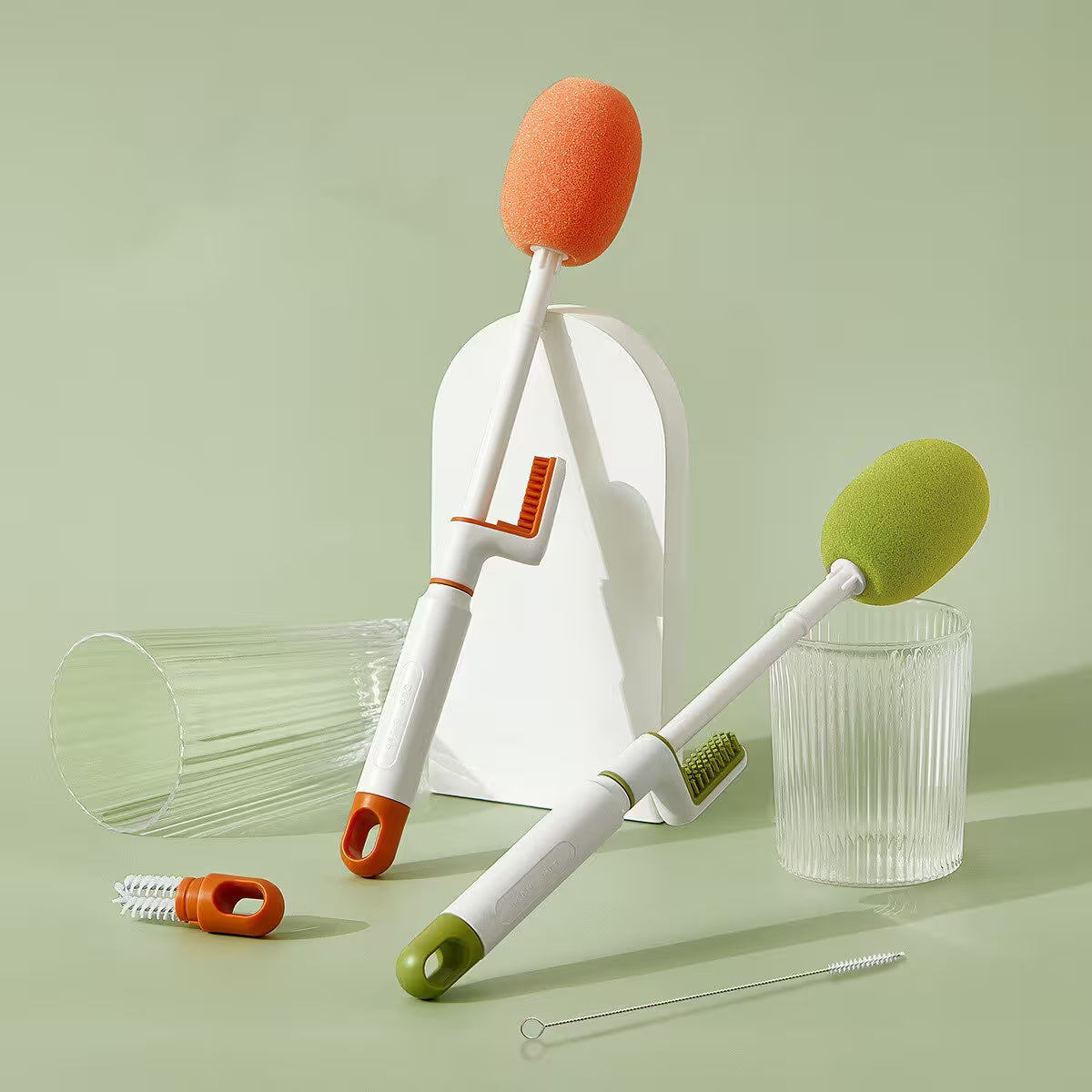 Set of cleaning tools with sponges and brushes on a light green background