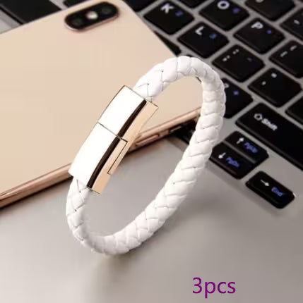 White braided bracelet with gold clasp on a laptop keyboard