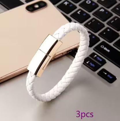White braided bracelet with gold clasp on a laptop keyboard