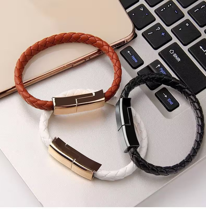 Two braided USB drives, one brown and one black, on a white surface with a laptop in the background.
