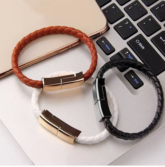 Two braided USB drives, one brown and one black, on a white surface with a laptop in the background.