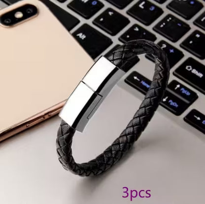 Black braided leather bracelet with silver clasp on a laptop keyboard
