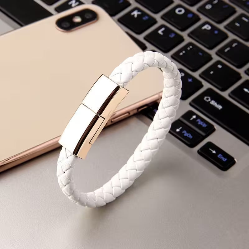 White braided bracelet with rose gold clasp on a laptop keyboard