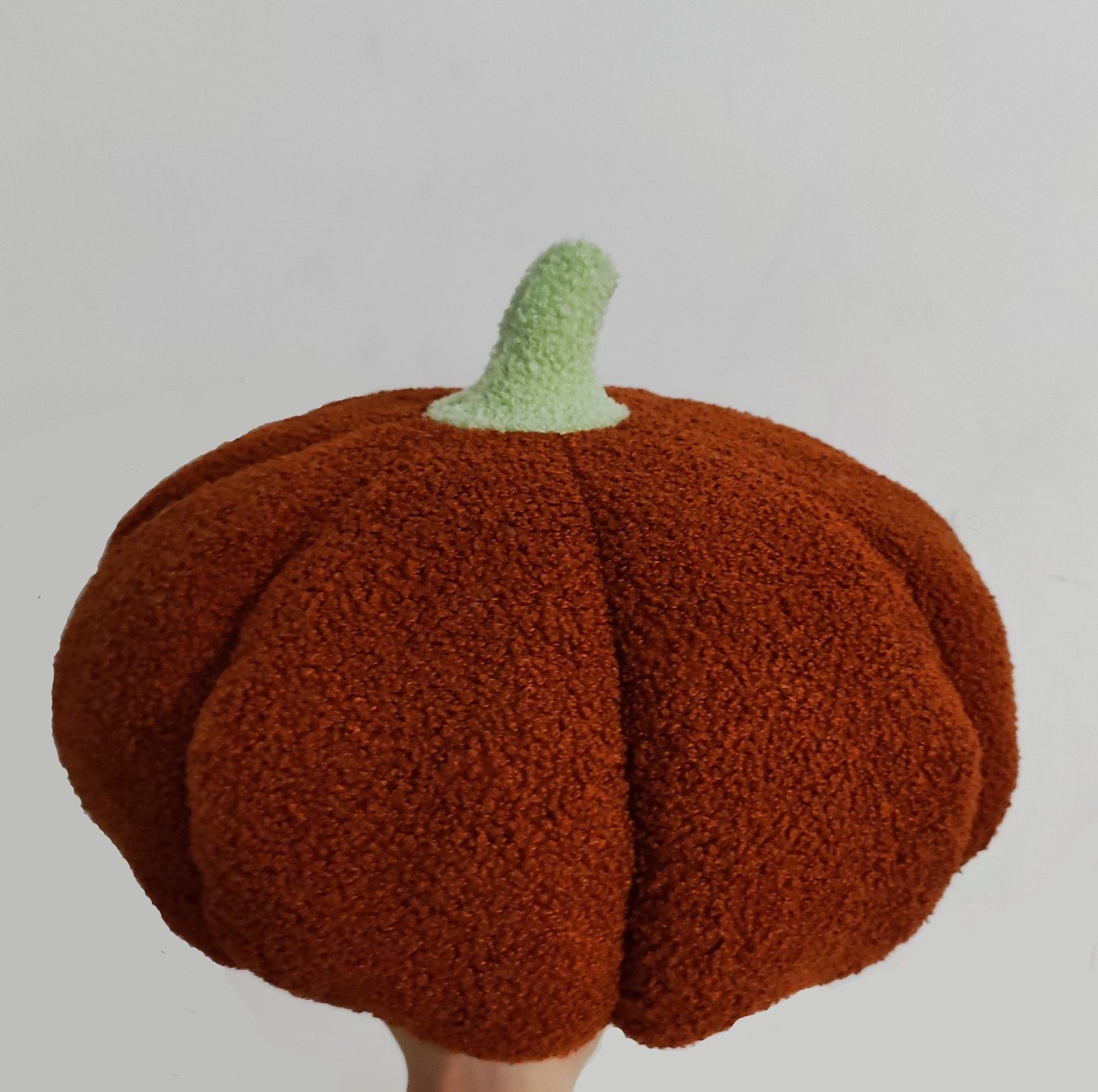 Pumpkin-shaped hat with a green stem on a gray background