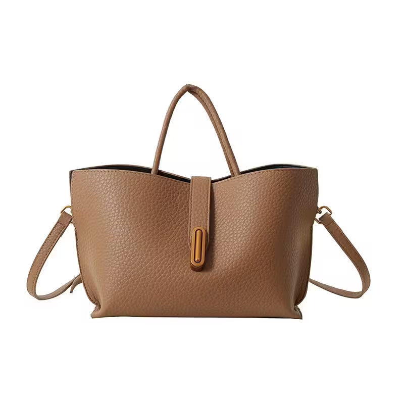 Brown leather tote bag with shoulder strap on a white background