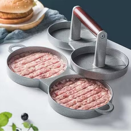 Hamburger press with ground meat patties on a white surface