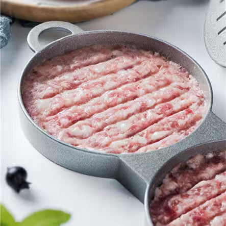 Raw ground meat in a muffin tin on a white surface with herbs and spices.