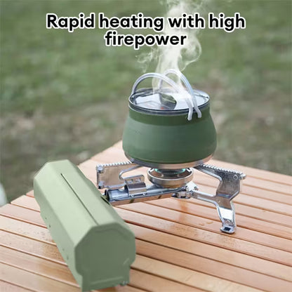 Green camping stove with a kettle on a wooden surface outdoors