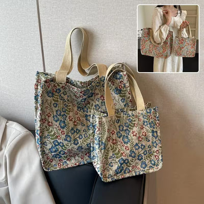 Floral-patterned tote bag with beige straps on a neutral background