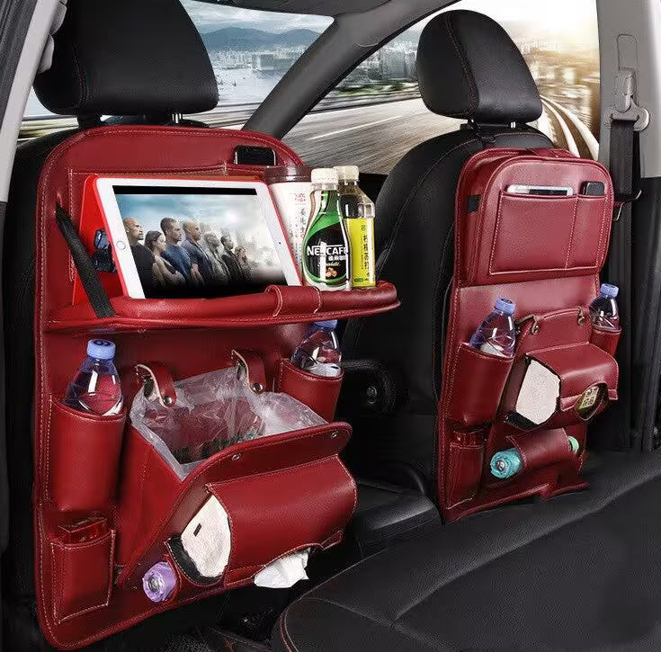 Red car seat back organizers with various items in a vehicle interior.