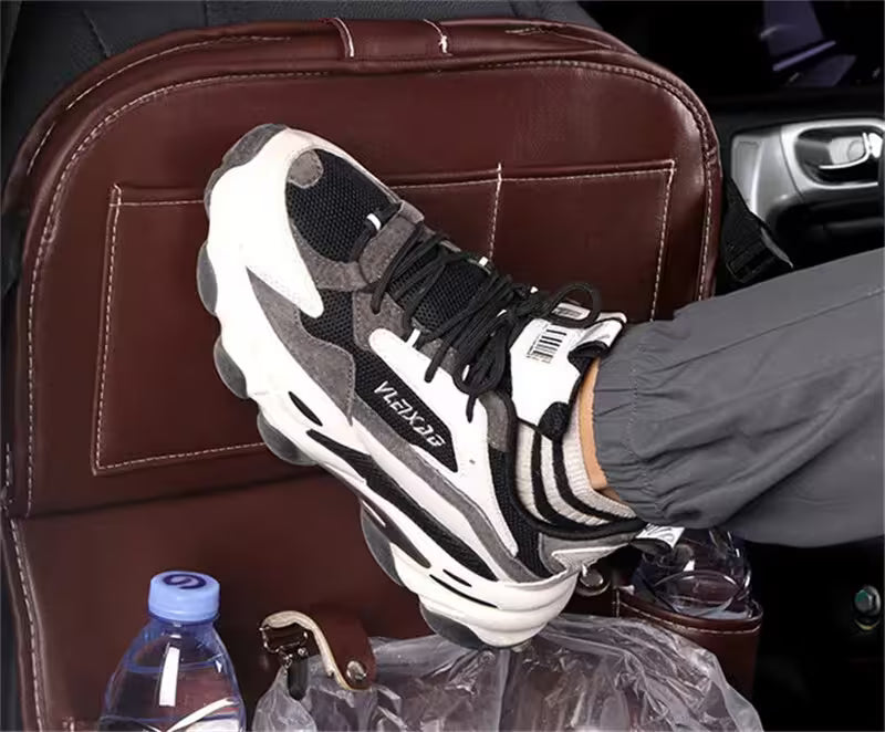 Person wearing a black and white sneaker with 'EXO' branding, sitting in a car.