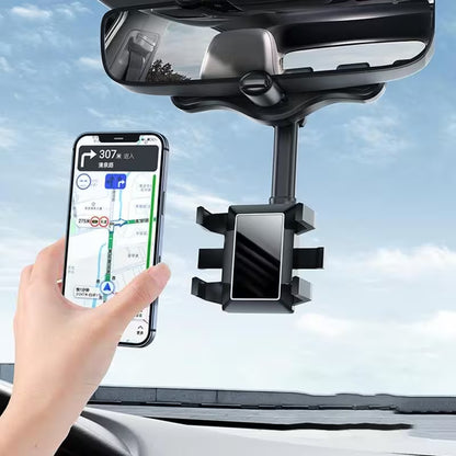 Car phone holder attached to a car's interior mirror with a hand holding a smartphone displaying navigation.