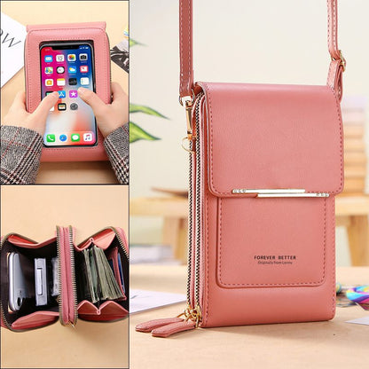 Pink crossbody bag with phone pocket and card holder on a wooden surface.