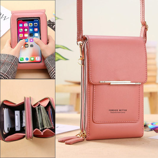 Pink crossbody bag with phone pocket and card holder on a wooden surface.