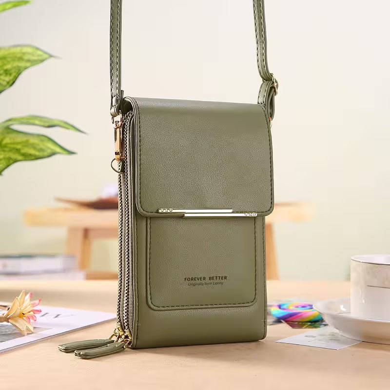 Green crossbody bag on a desk with a blurred indoor background