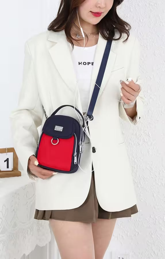 Person wearing a white blazer with a red and blue backpack against a white background