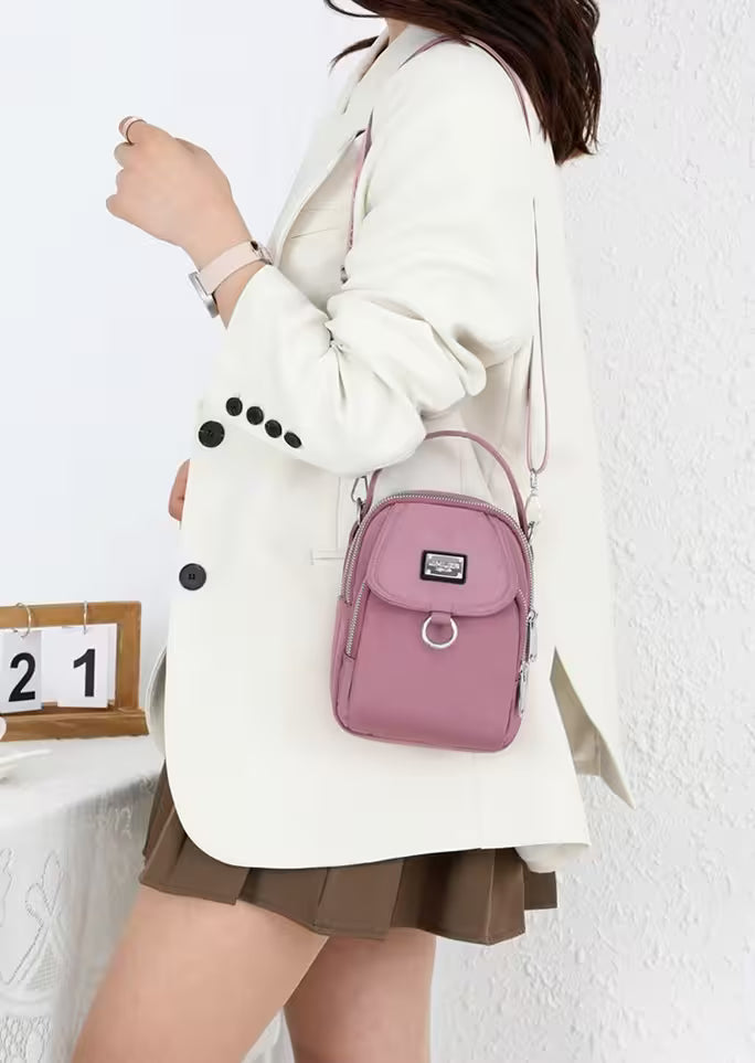 Person wearing a white coat with a pink backpack against a white wall.