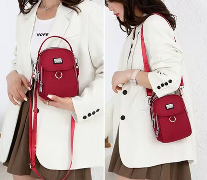 Person wearing a white coat with a red backpack, holding it in front of a white background.