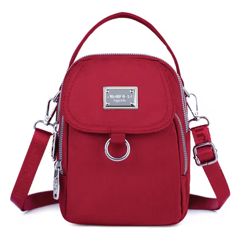 Red crossbody bag with silver accents on a white background