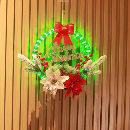 Decorative Christmas wreath with lights, flowers, and a red bow on a wooden background.