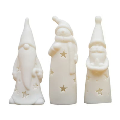 Three white ceramic figures with star designs on a white background