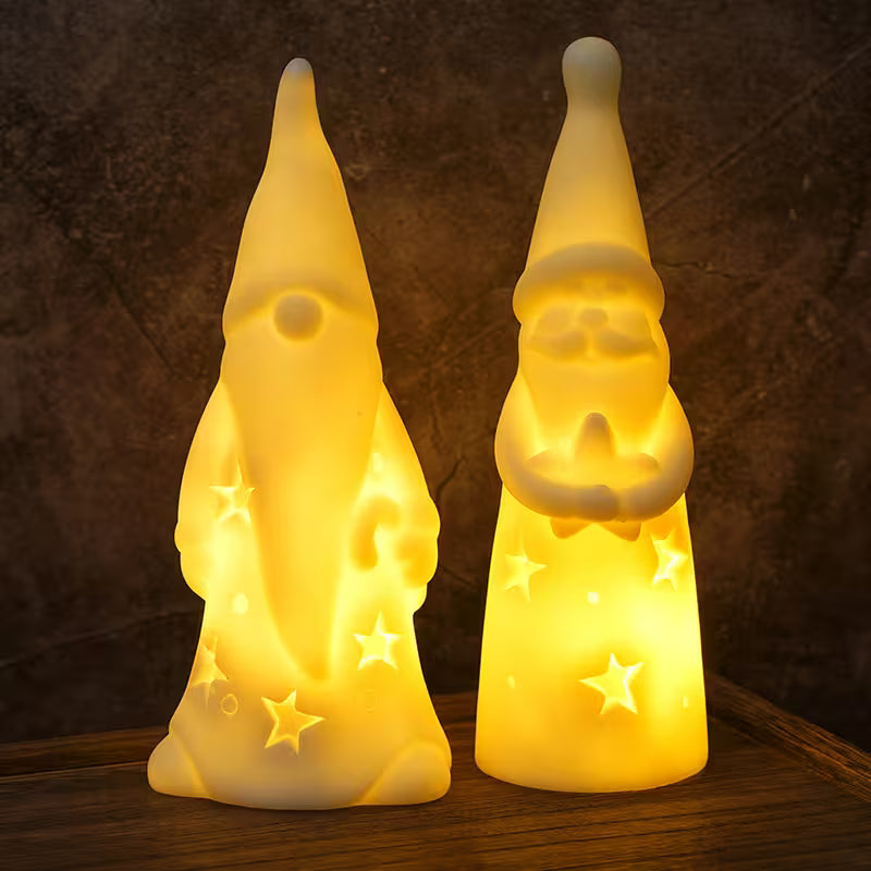Two glowing gnome-shaped lamps on a wooden surface with a dark background