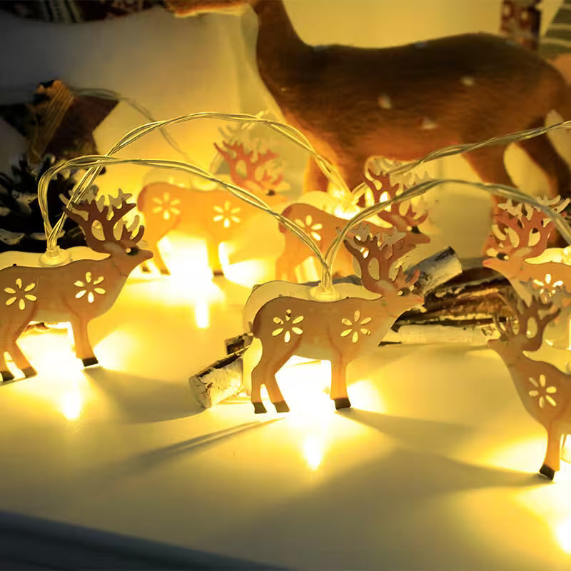 Decorative string lights shaped like deer on a white surface with a blurred background