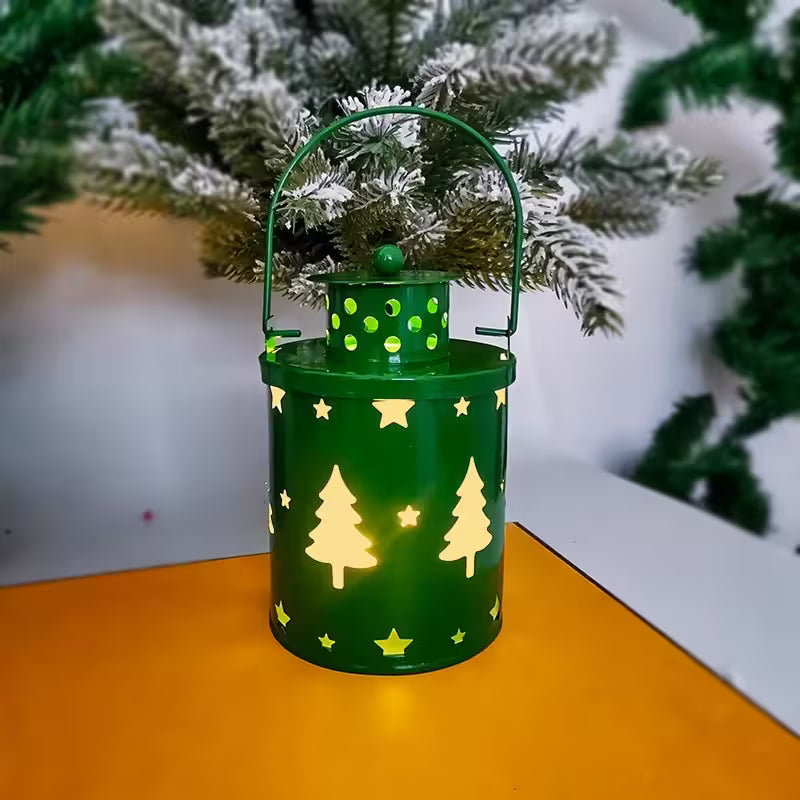 Green lantern with tree and star patterns on a wooden surface with a Christmas tree in the background