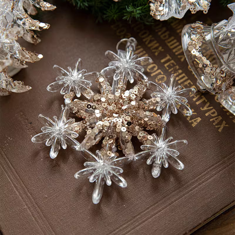 Decorative snowflake with clear and gold elements on a textured surface