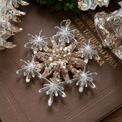 Decorative snowflake with clear and gold elements on a textured surface