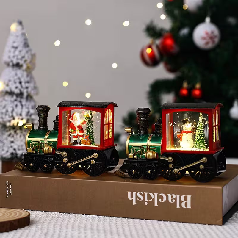 Decorative Christmas train set with Santa and snowman figures on a box, with Christmas trees in the background.