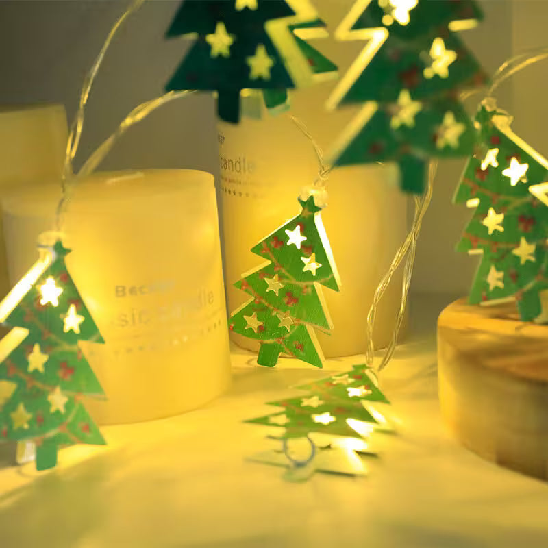Decorative Christmas tree lights with candles on a wooden surface