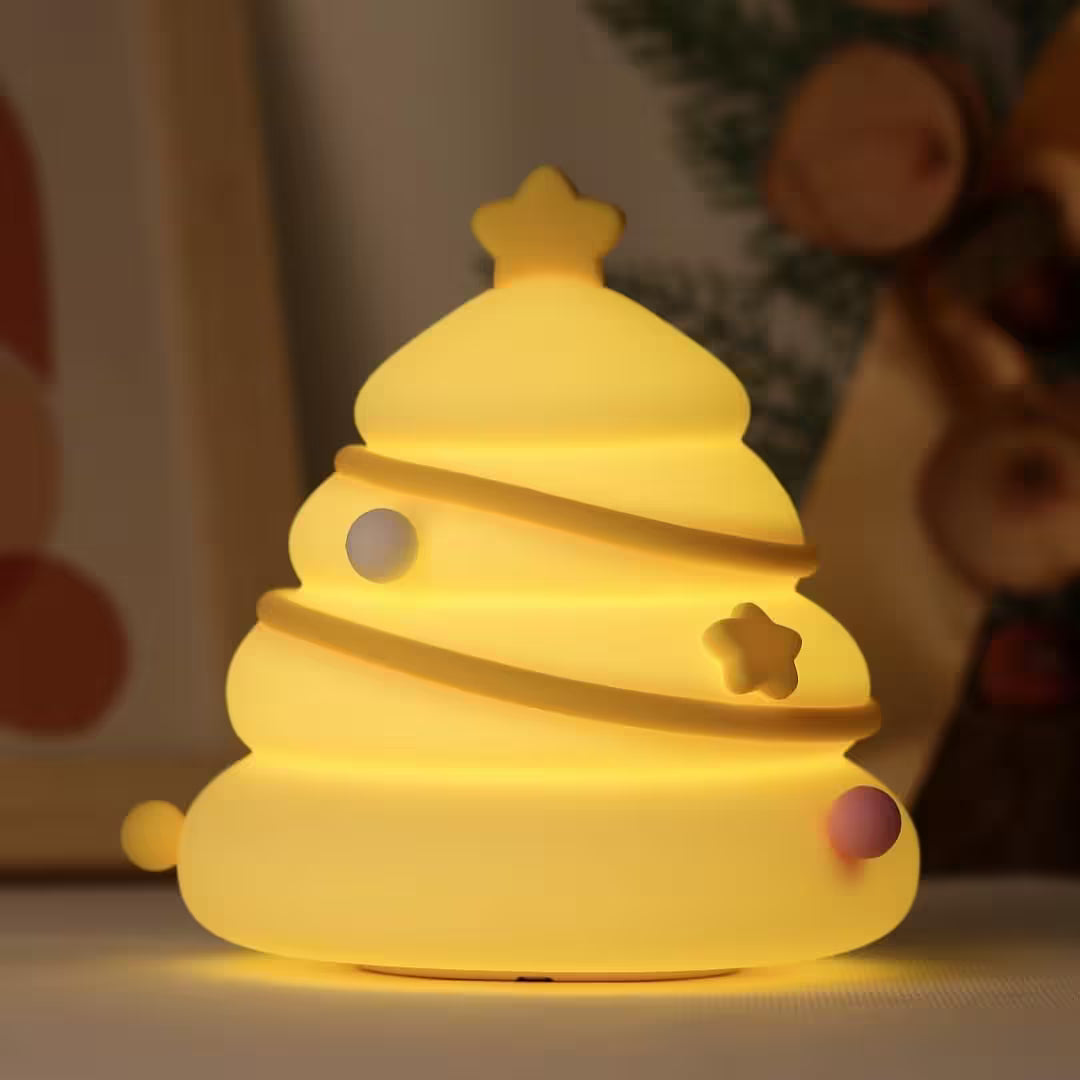 Yellow night light shaped like a Christmas tree with stars and balls on a blurred background