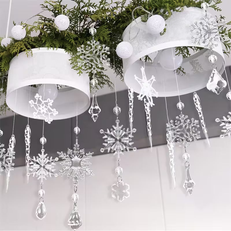 Decorative snowflake and crystal hanging ornaments on a white background with greenery.