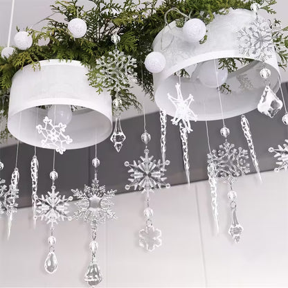 Decorative snowflake and crystal hanging ornaments on a white background with greenery.