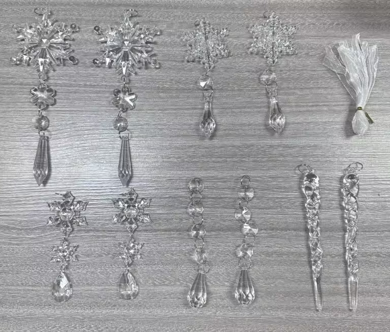 Set of crystal snowflake and teardrop decorations on a textured surface