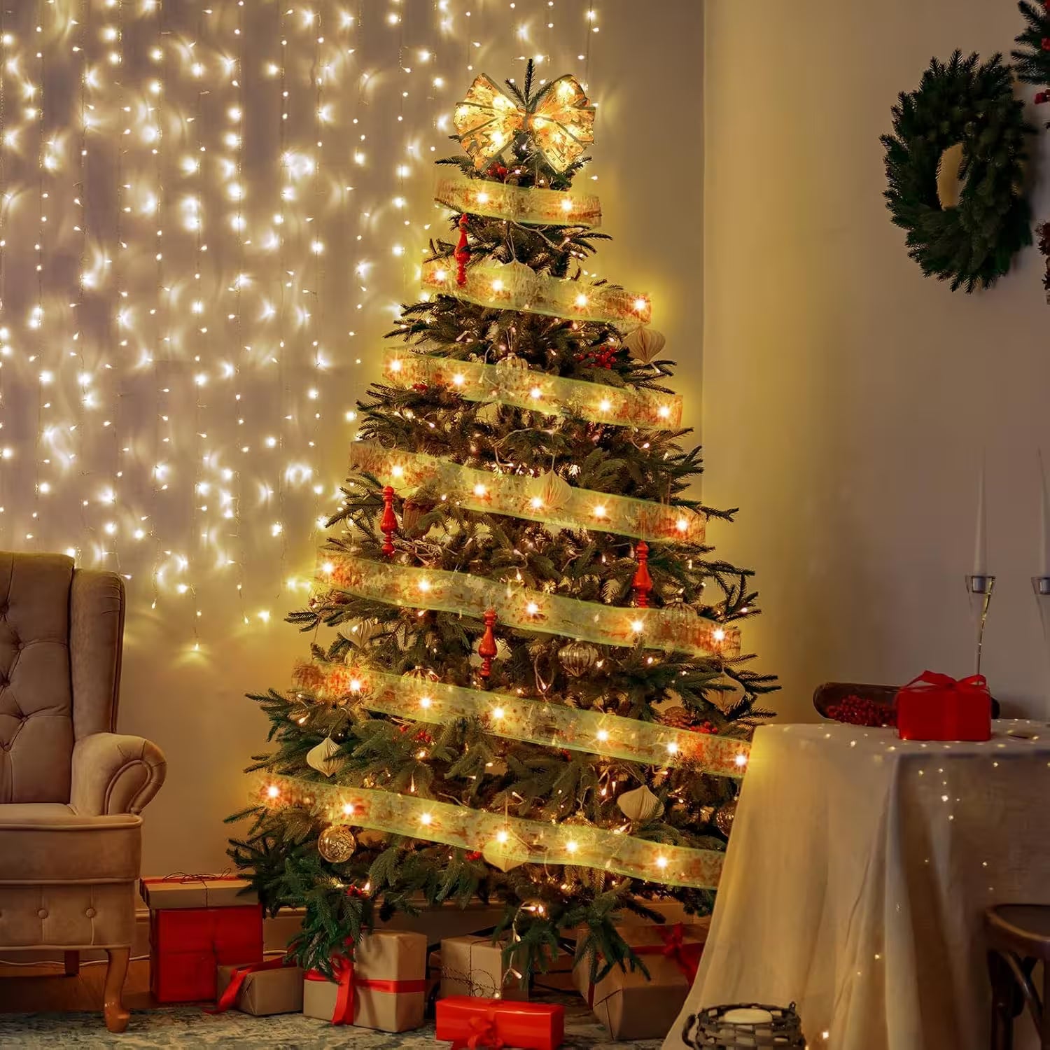 Decorated Christmas tree with lights in a room with a wreath and gift boxes.