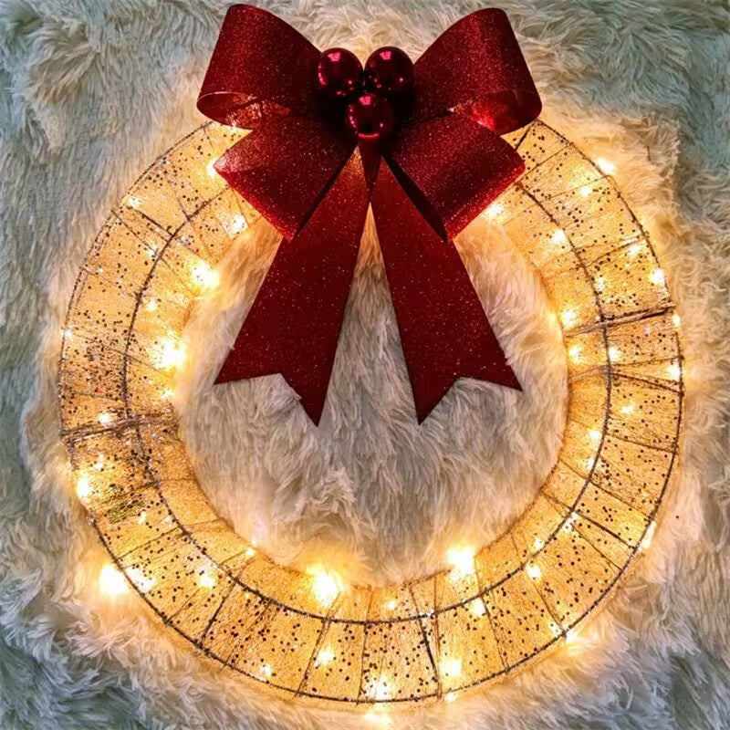 Decorative wreath with a red bow and string lights on a fluffy surface