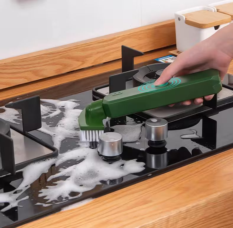 Person using a green cleaning tool on a stove with soap suds.